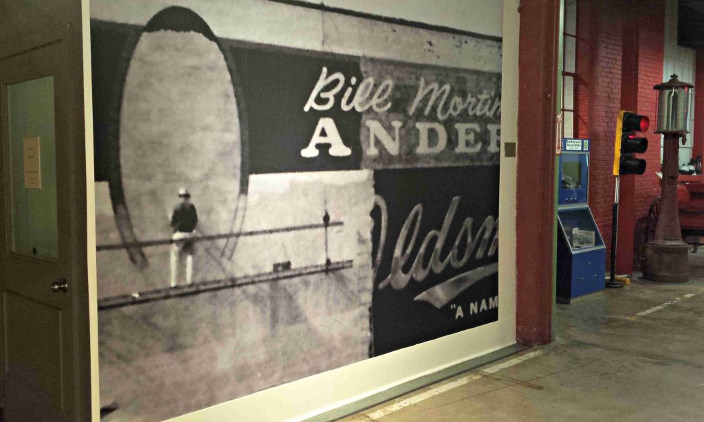A 1950s “walldog” paints a sign for a car dealership in Baltimore.