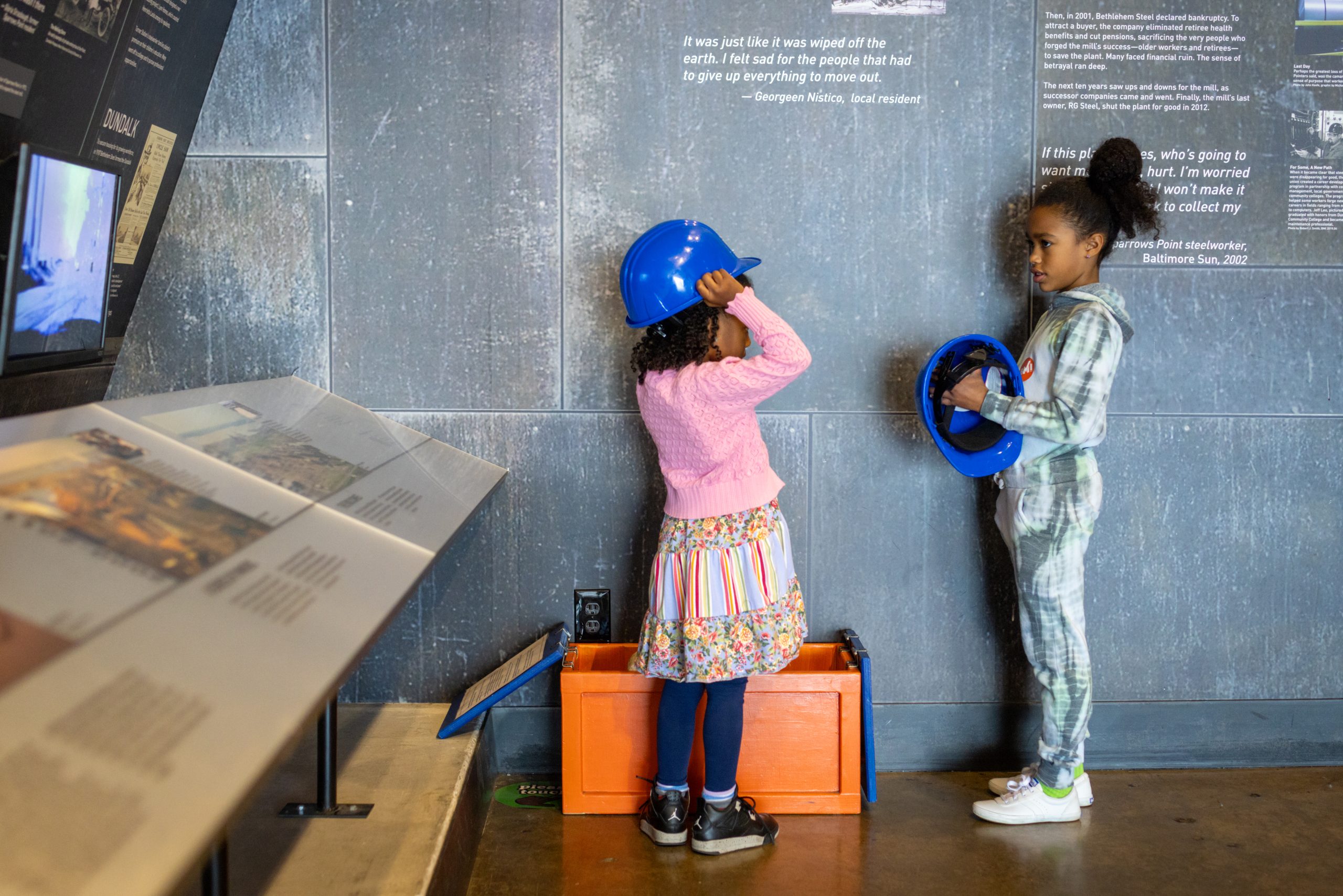 children trying on hard hats at museum