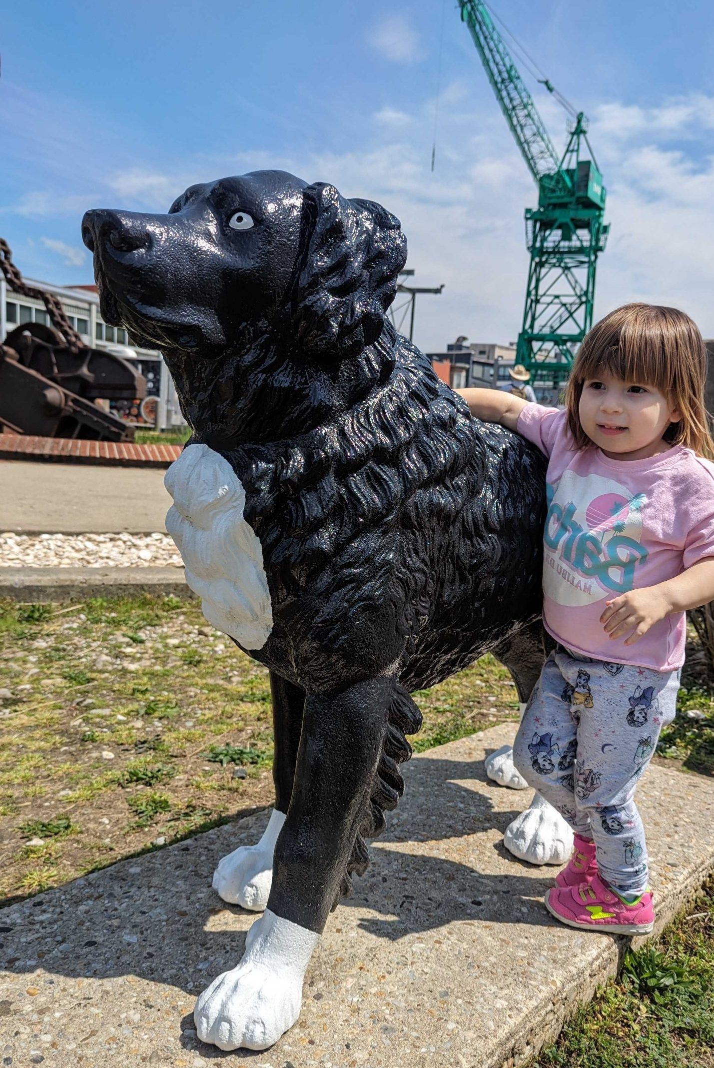 child petting dog statue