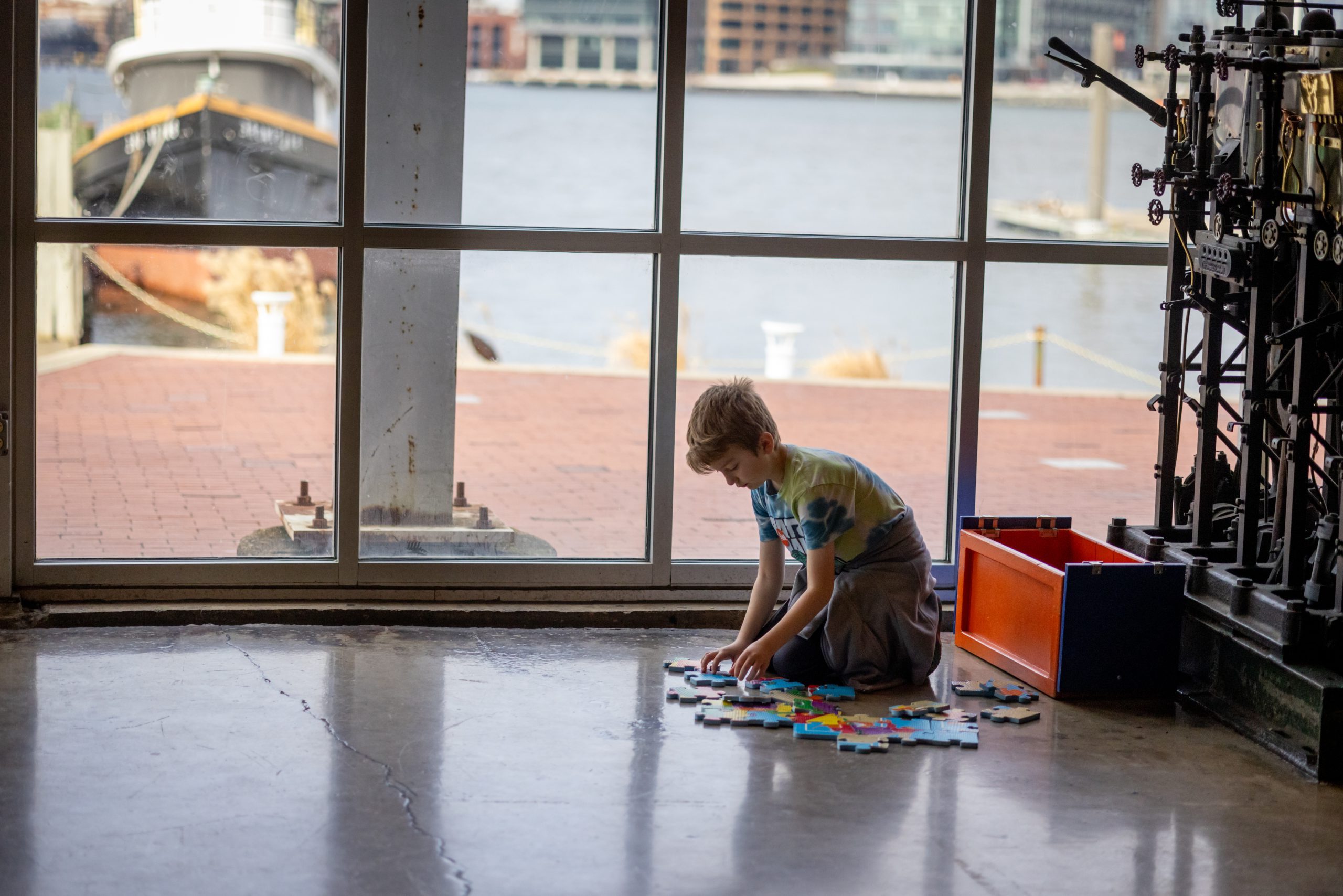 child doing a puzzle on floor of museum