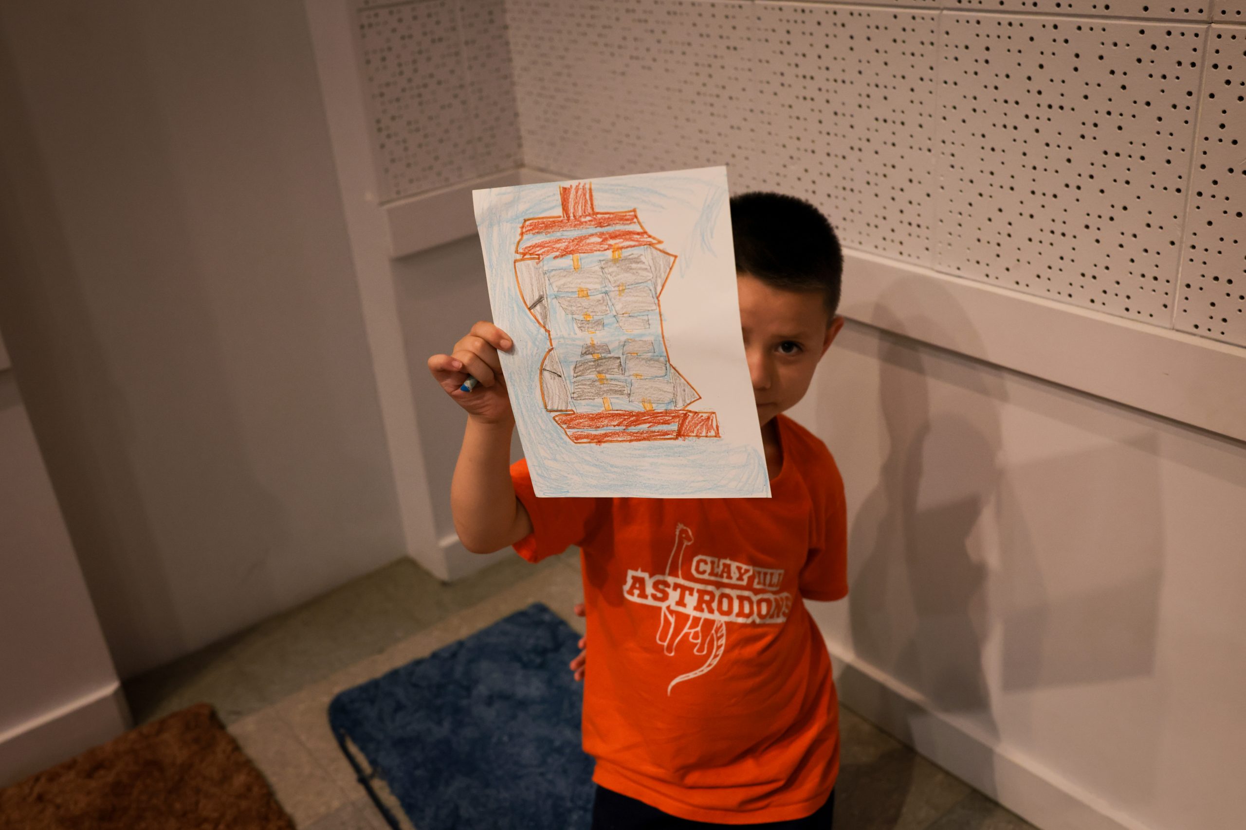 child proudly showing drawing