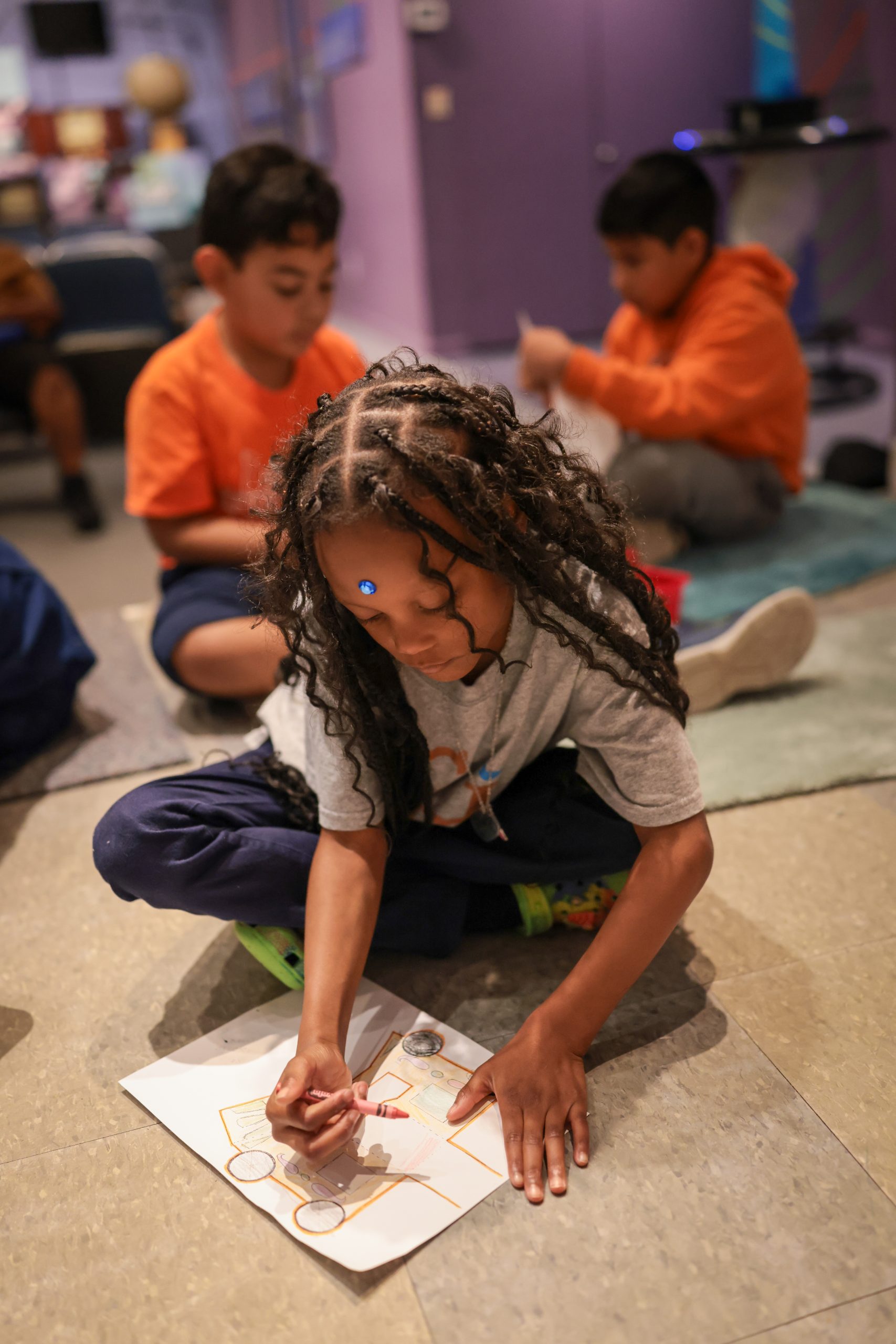 children sitting on floor drawing