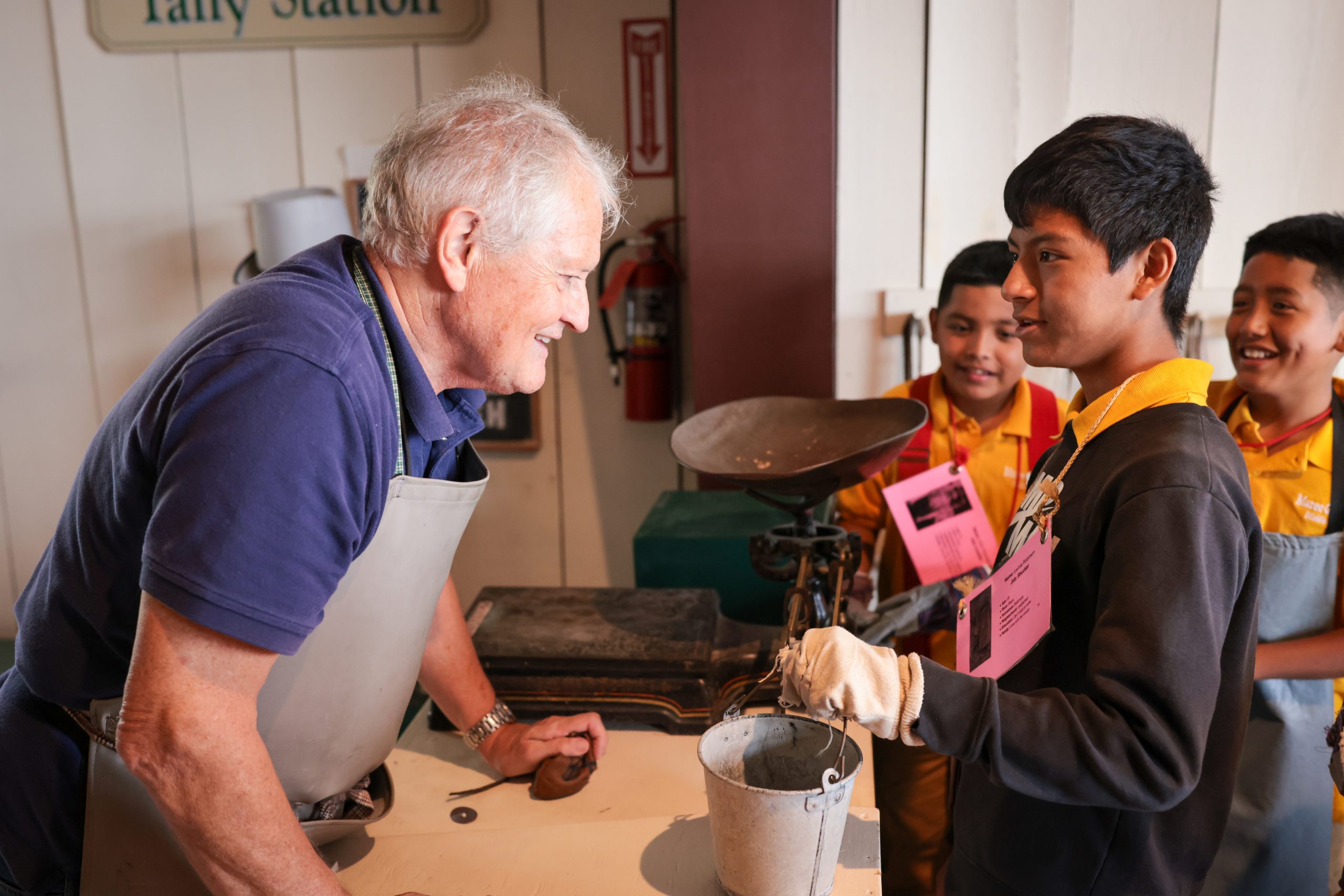 museum teacher working with student in cannery activity